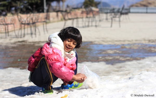 A Small girl making snowballs