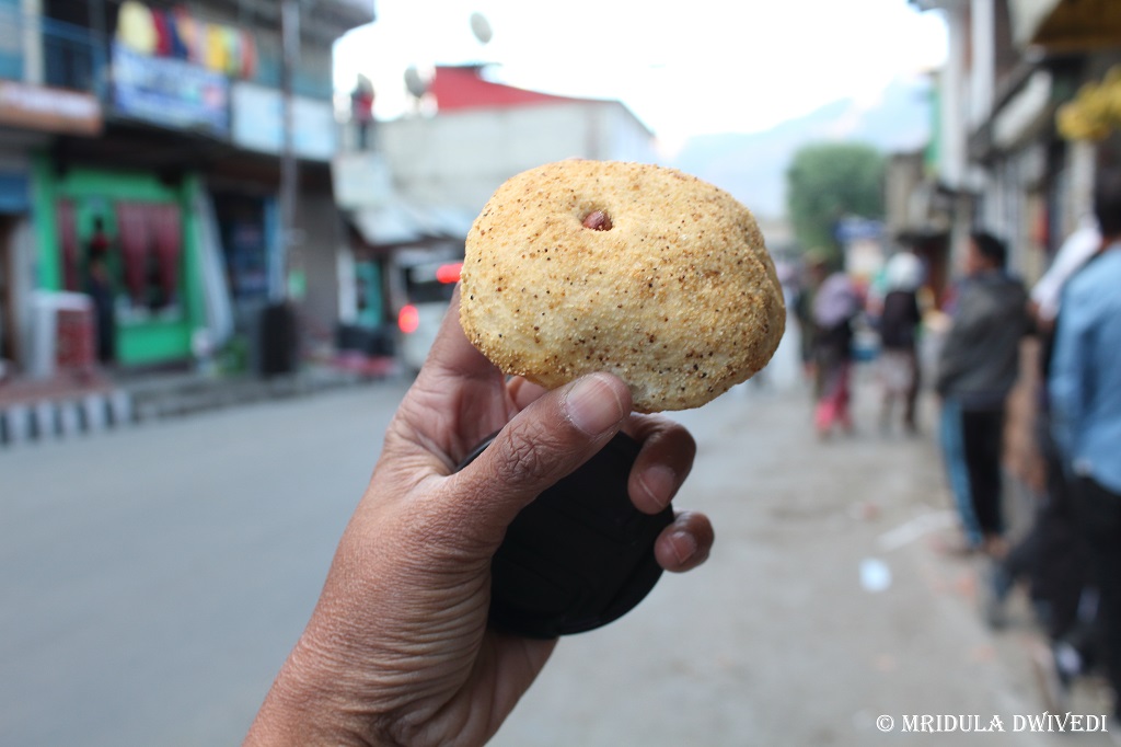A savory local snack, also known as Ladakhi Biscuit against the backdrop of the main market in Kargil.
