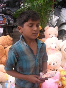 Young boy selling soft toys