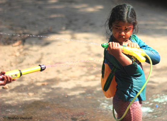 A small girl playing holi