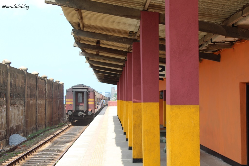 A train passing by at the colorful Kollupitiya Train Station in Colombo Sri Lanka